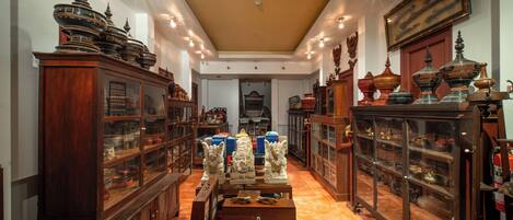A hallway with wooden cabinets and glass display cases containing various items.