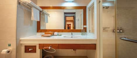 A modern bathroom with a glass shower enclosure, a wooden vanity, and a large mirror.