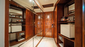 Une salle de bain moderne avec des meubles en bois, une douche en verre et un sol carrelé de couleur blanche.