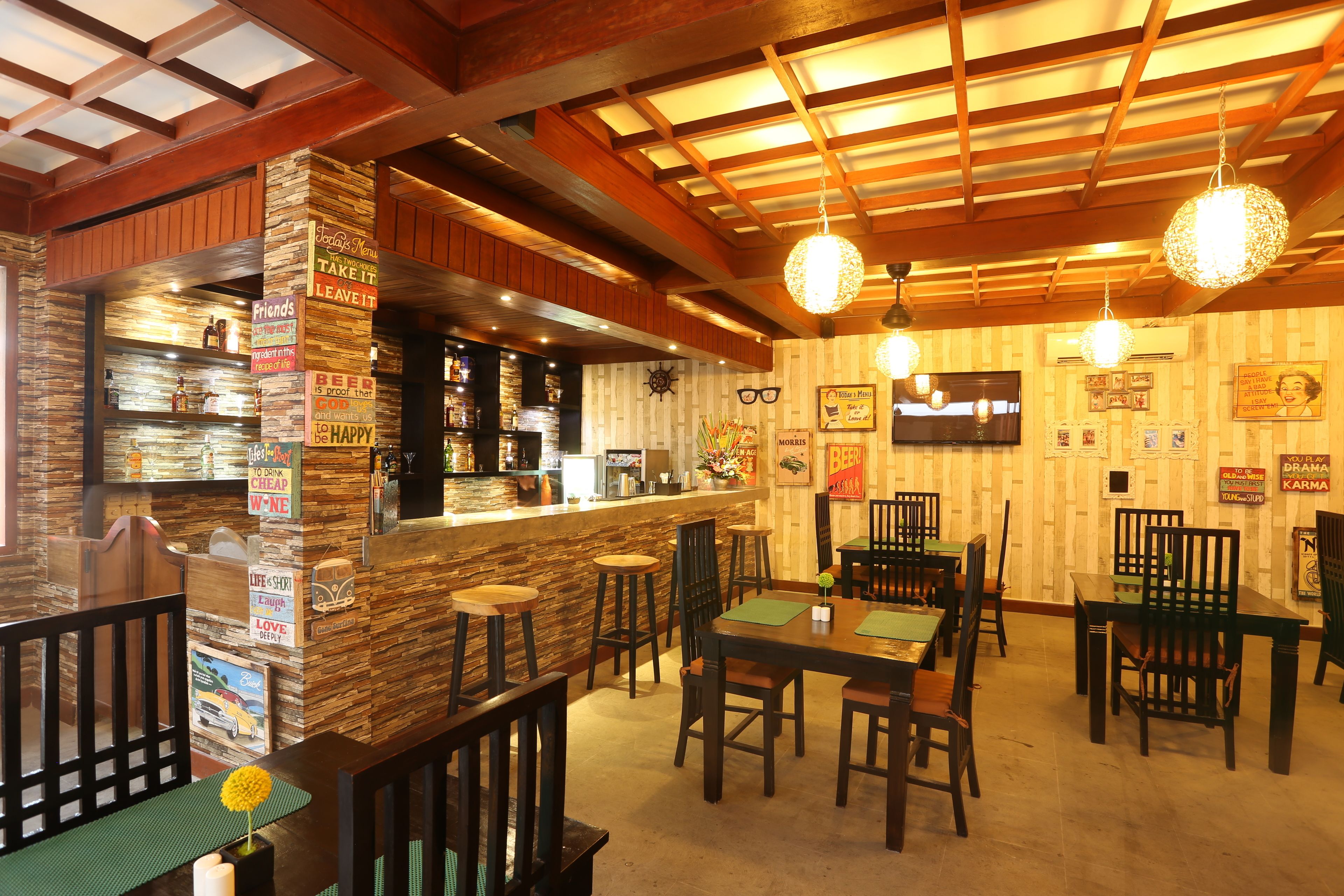 A restaurant with wooden beams, a bar area, and several tables and chairs.