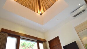 A room with a sloped ceiling, large windows, and a flat-screen TV. - The Jas Villas (Seminyak)