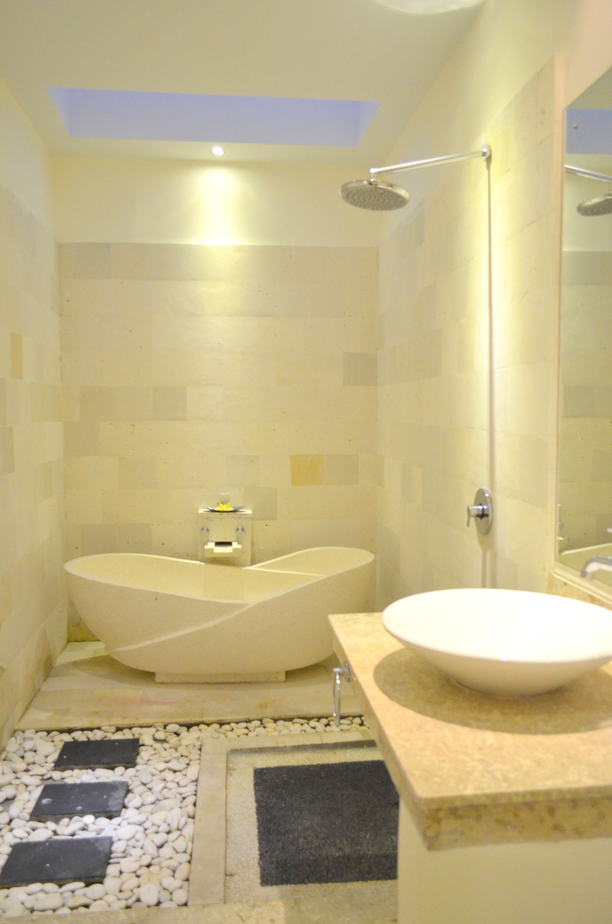 A modern bathroom with a freestanding bathtub, a separate sink, and a walk-in shower.