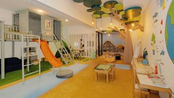 Explore and learn in this vibrant playroom featuring a slide, climbing ladder, and play table with toys and books.