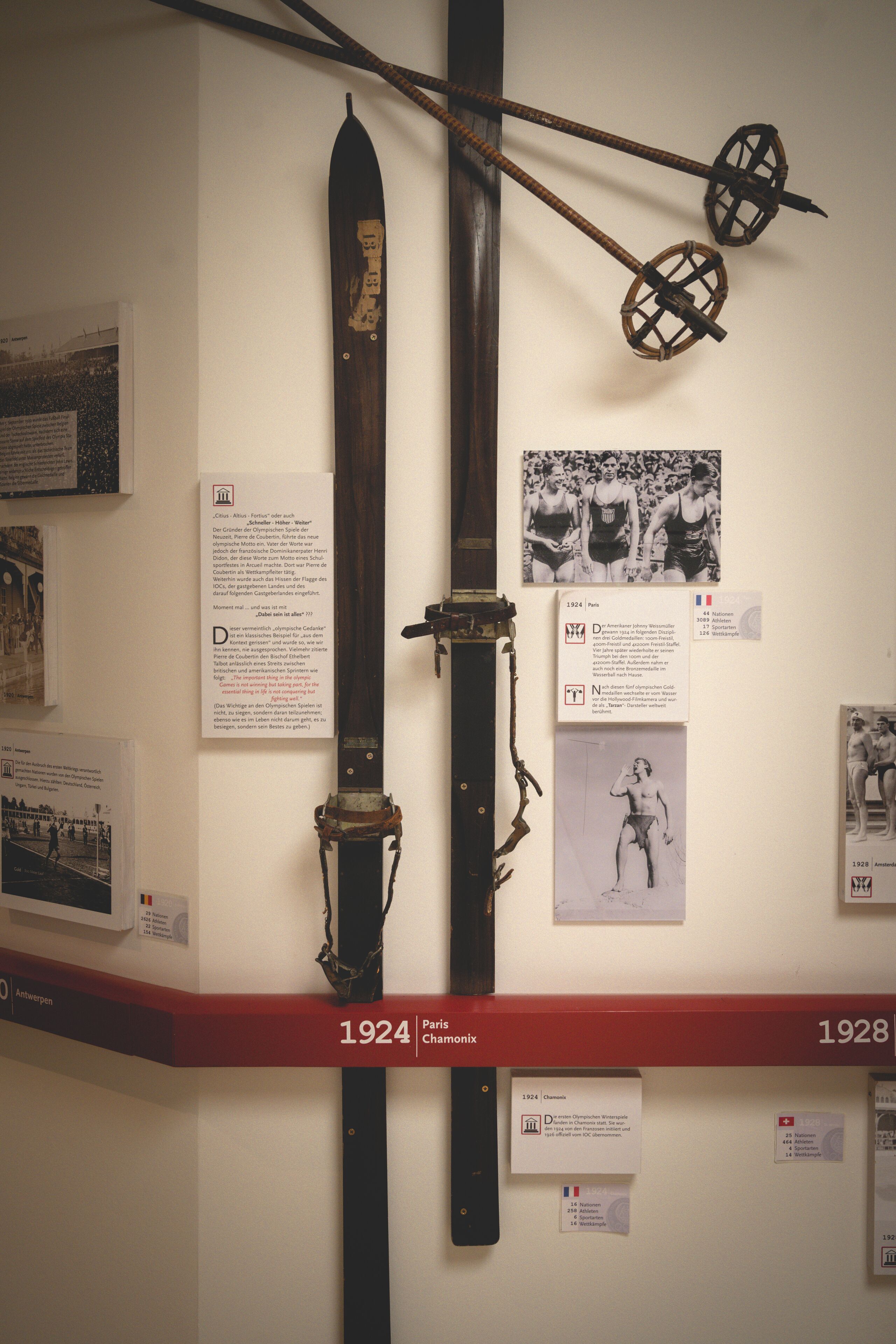 A display of historical swords with informational plaques and photographs.