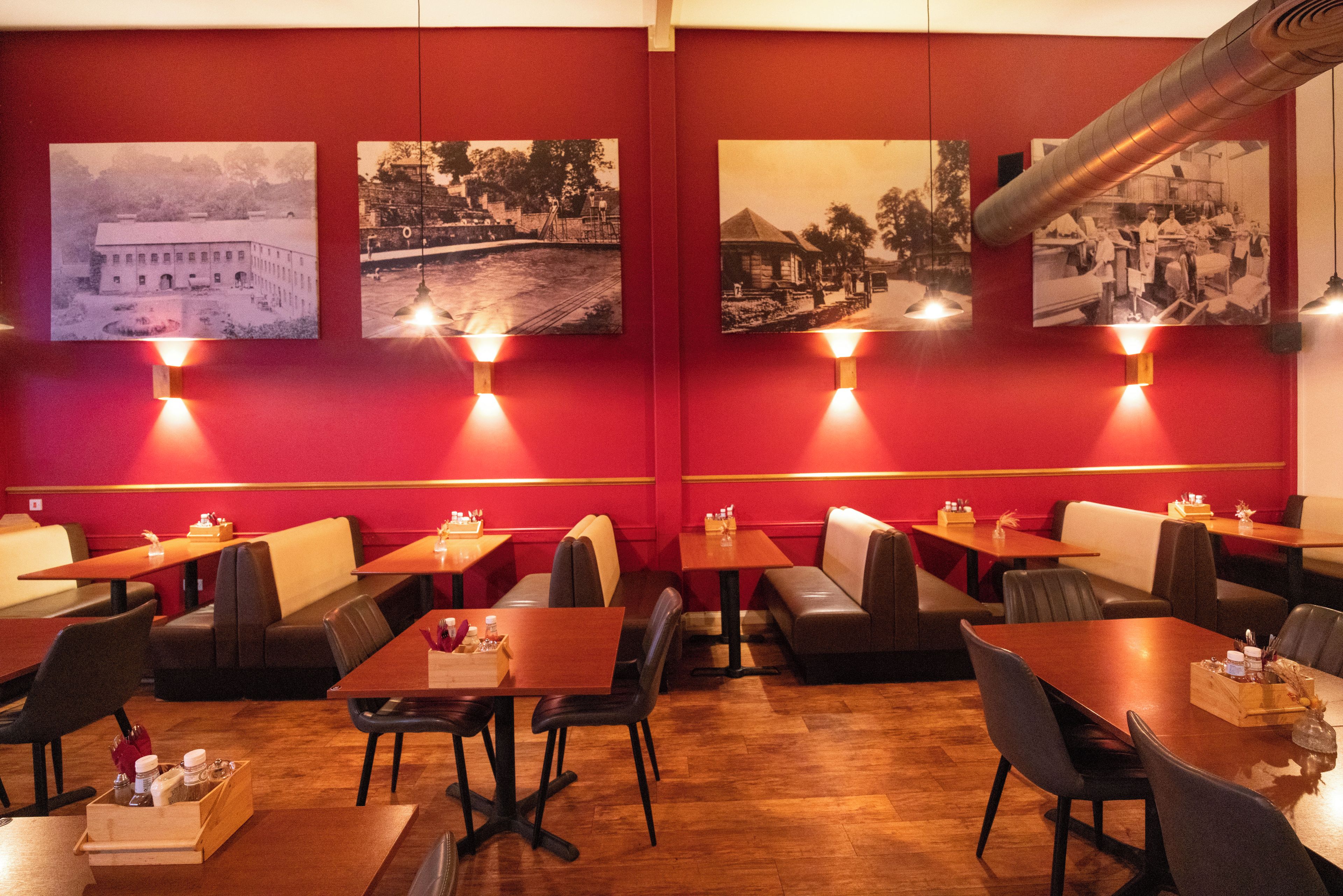 A restaurant interior with booths, tables, and wall-mounted light fixtures.