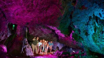 Un grupo de personas dentro de una cueva con iluminación de colores.