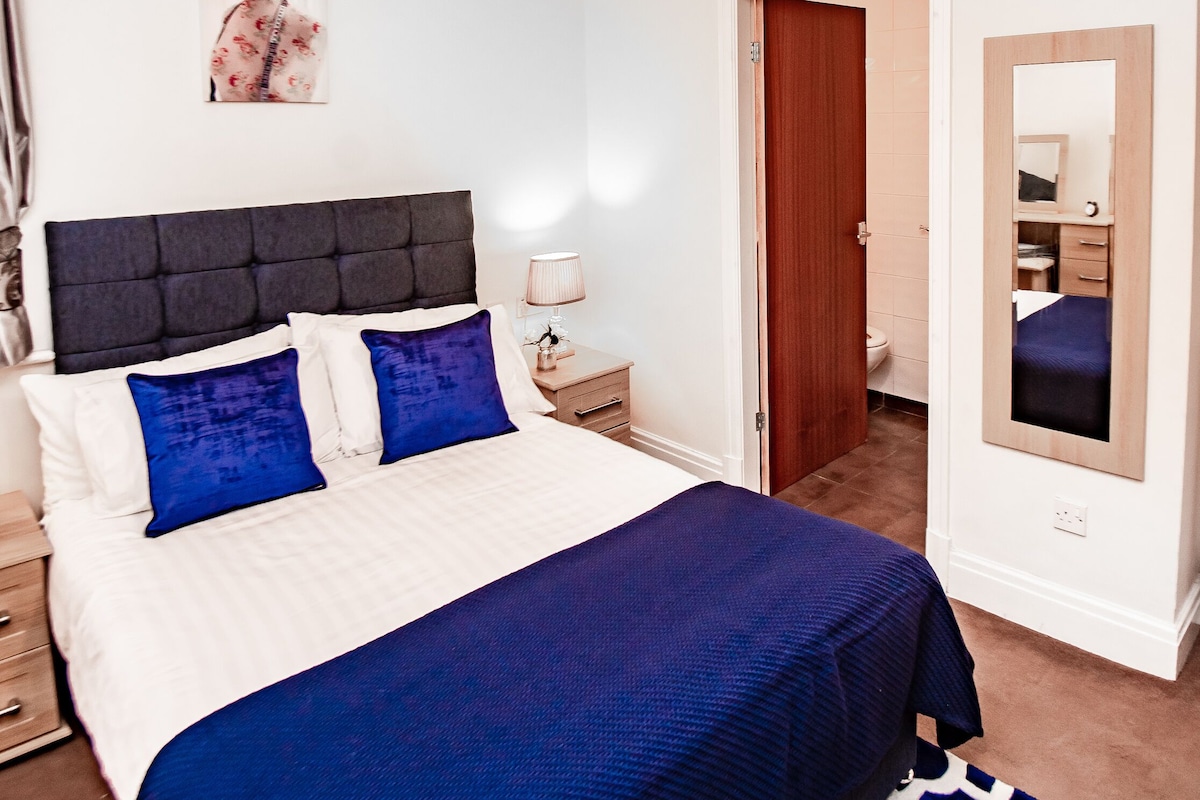 Un dormitorio con cama, mesita de noche y espejo.