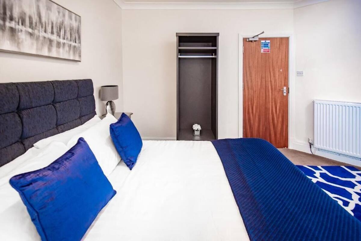 Habitació d'hotel amb llit, armari, porta i radiador.