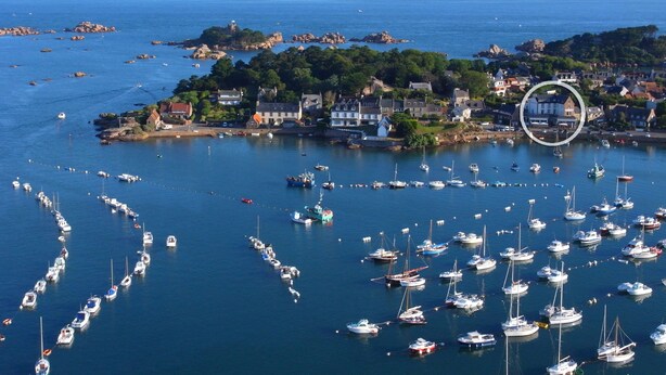 A coastal town with a marina filled with boats, houses, and rocky outcrops. - Hôtel des Rochers (Perros-Guirec)
