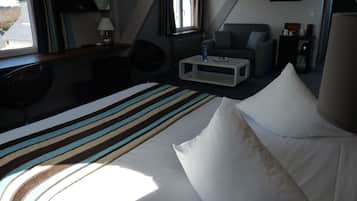 Una habitación de hotel con cama, escritorio, silla, sofá y mesa de centro.