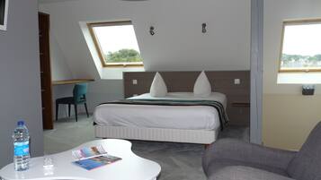 Una habitación de hotel moderna con una cama, un escritorio, una silla, una botella de agua y una revista sobre una mesa blanca.