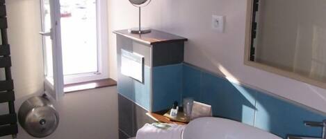 A bathroom with a toilet, sink, and mirror.