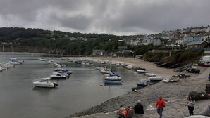 A coastal town with a marina filled with boats, a sandy beach, and residential buildings in the background. - Feathers Hotel, Bar and Restaurant (Aberaeron)