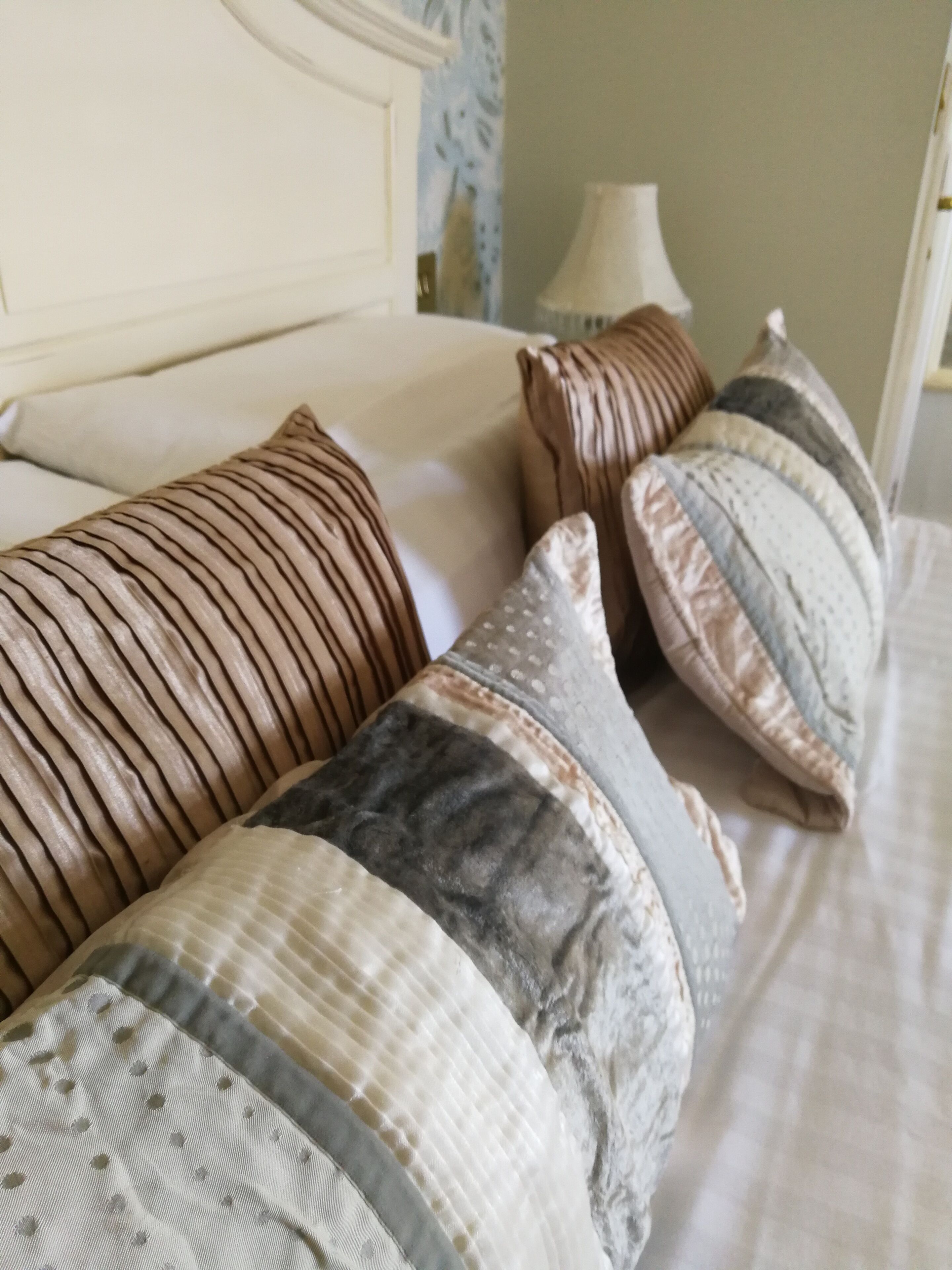 A bed with multiple pillows and a headboard.