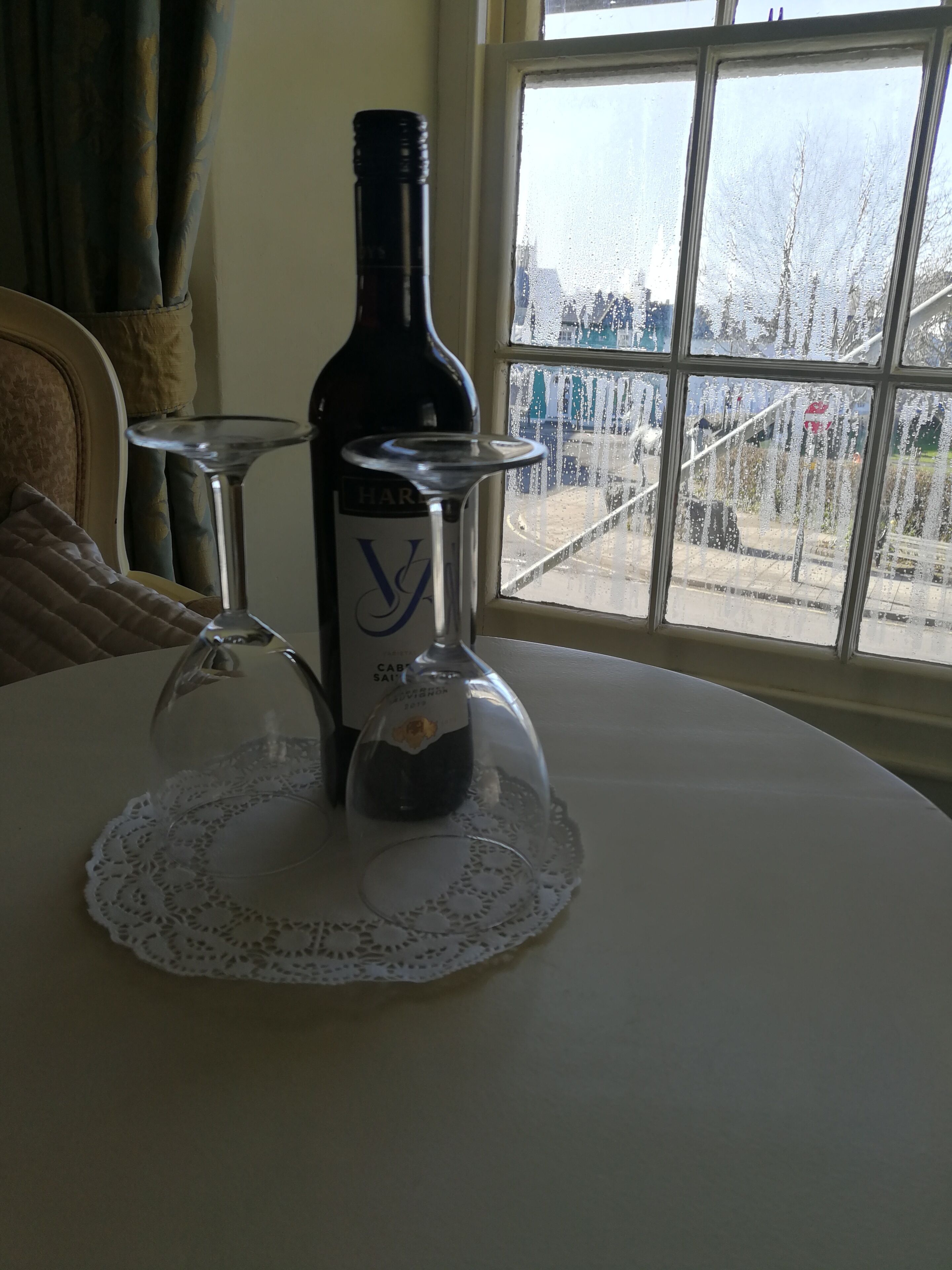 Une bouteille de vin sur une table, avec un verre et un verre à vin.