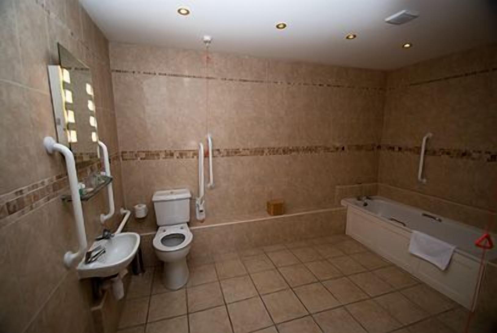 Een badkamer met toilet, wastafel en bad.