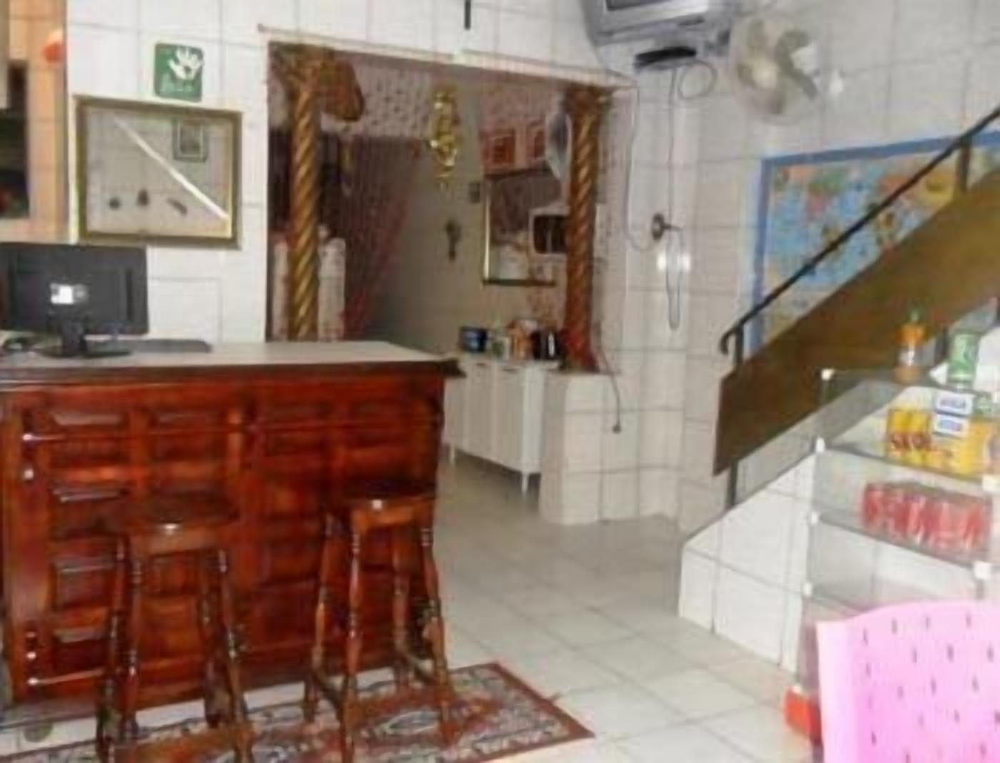 Una cocina con barra de madera, armarios blancos y salpicadero de azulejos.