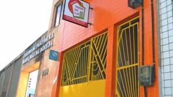 Un edificio con fachada naranja brillante, puertas amarillas y un letrero que indica restaurante.