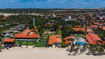 Resort com várias construções, piscina e área de praia.