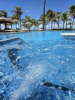 Een buitenzwembad, parasols voor strand/zwembad