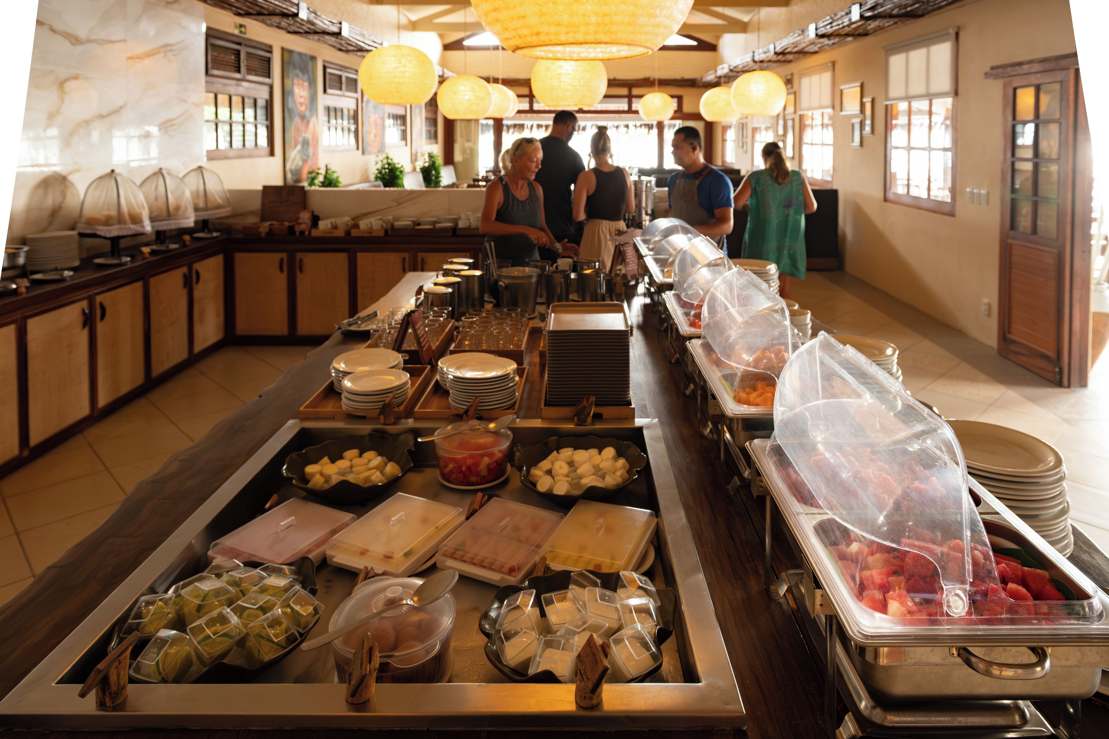 Disposição de buffet com diversos alimentos e utensílios de servir.
