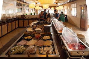 Una mesa de buffet con diferentes alimentos y utensilios de servir.