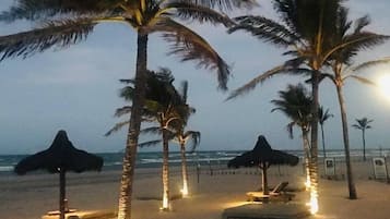 On the beach, white sand, sun-loungers, beach towels