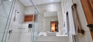 A modern bathroom with a glass shower enclosure, a wooden vanity, and a large mirror. - Rede Beach (Trairi)