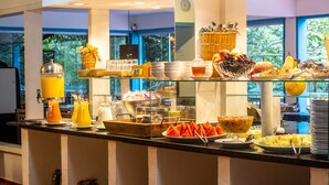 A buffet with various food items and beverages, including fruits, vegetables, and a juice dispenser. - Hotel Miratlântico Búzios (Búzios)