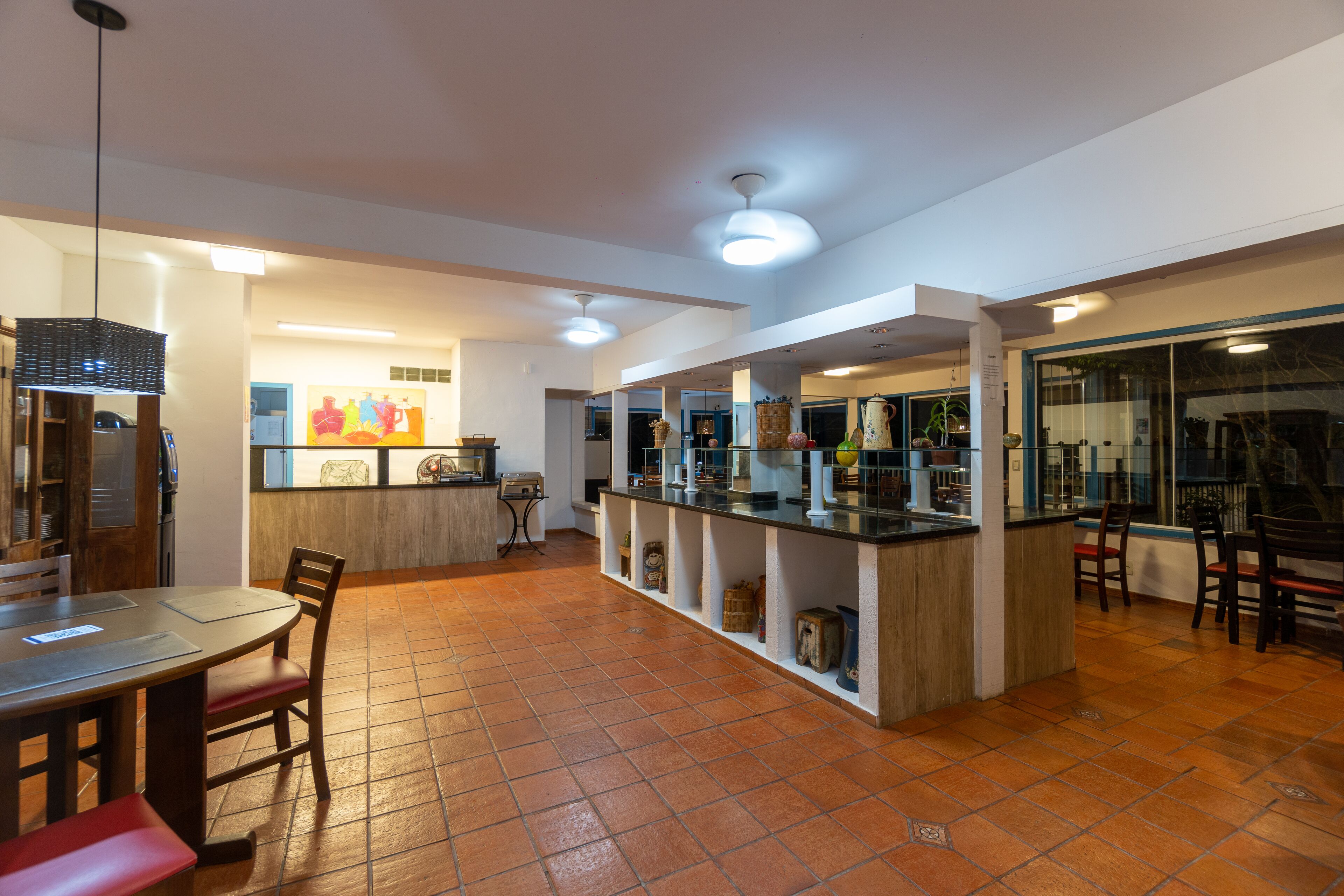 A spacious kitchen area with a central island, a dining table with chairs, and a bar area with stools.