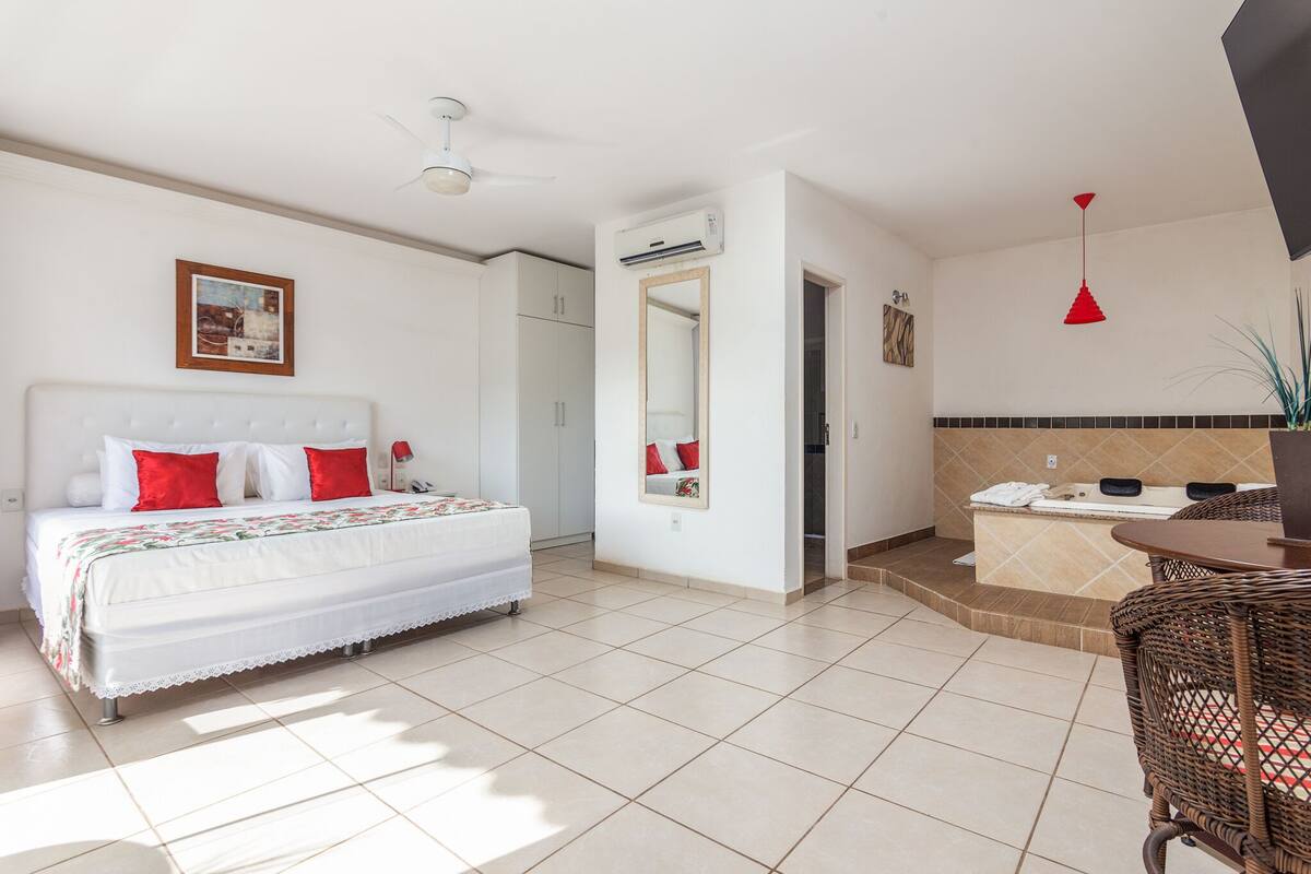 Une chambre d’hôtel comprenant un lit, une salle de bain et un petit coin salon.