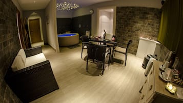 Ein modernes Badezimmer mit einer Badewanne, einer Dusche und einem WC. In der Mitte des Raumes befinden sich ein Tisch und Stühle.