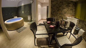 Un baño moderno con bañera, zona de ducha y una mesa de comedor con sillas.