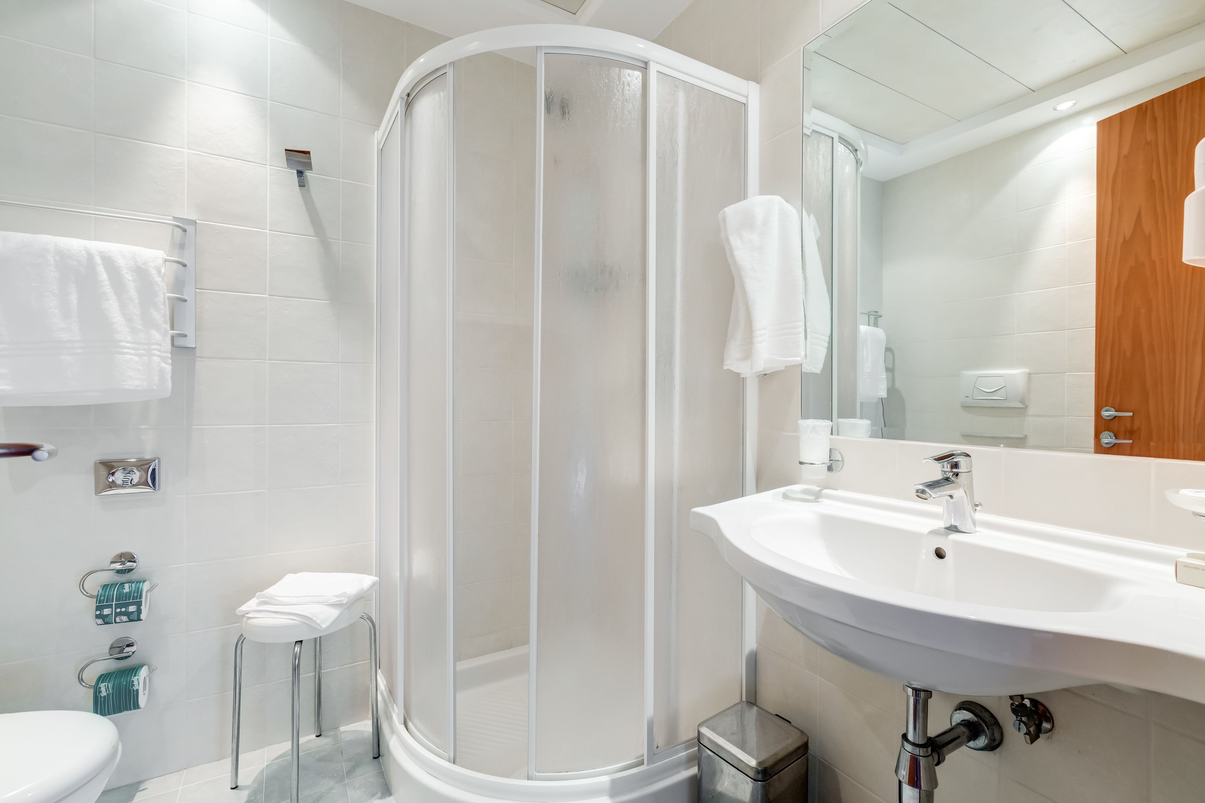 Une salle de bain moderne avec une douche à parois de verre, un lavabo blanc et des toilettes.