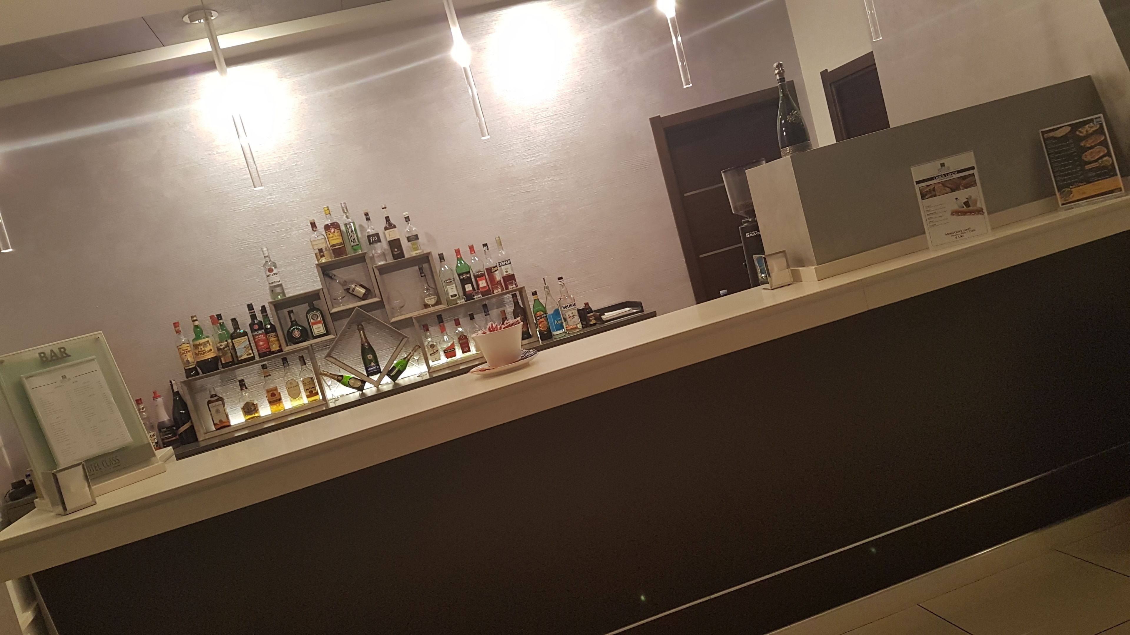 Eine Bar mit Regalen voller Spirituosenflaschen und Gläsern.