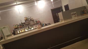Eine Bar mit Regalen voller Spirituosenflaschen und Gläsern.