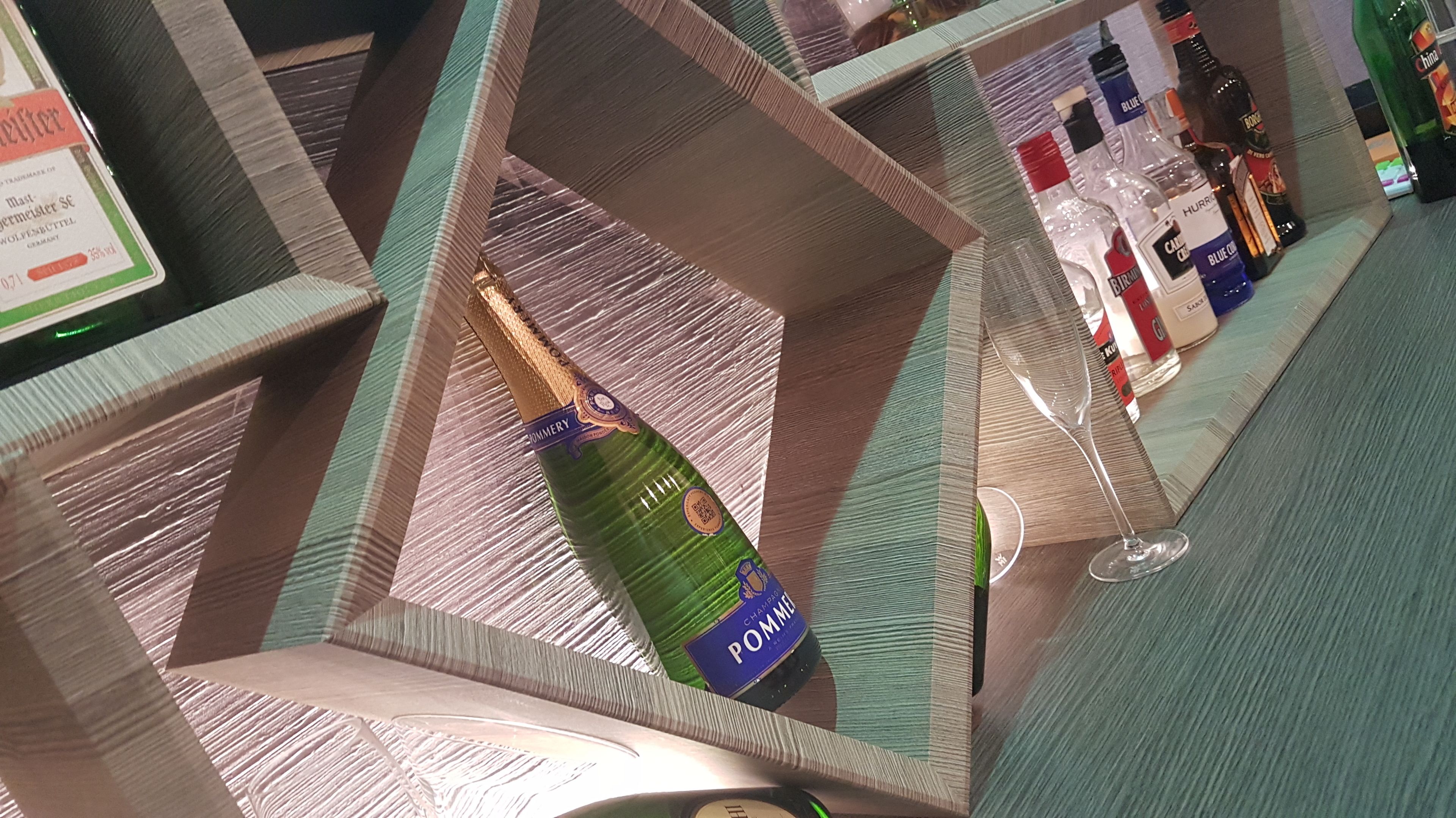 Una bottiglia di champagne in un elegante porta bicchieri su un bancone bar.
