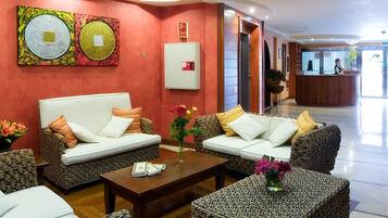 Eine Lobby mit zwei Sofas, einem Couchtisch und einem Empfangstresen.