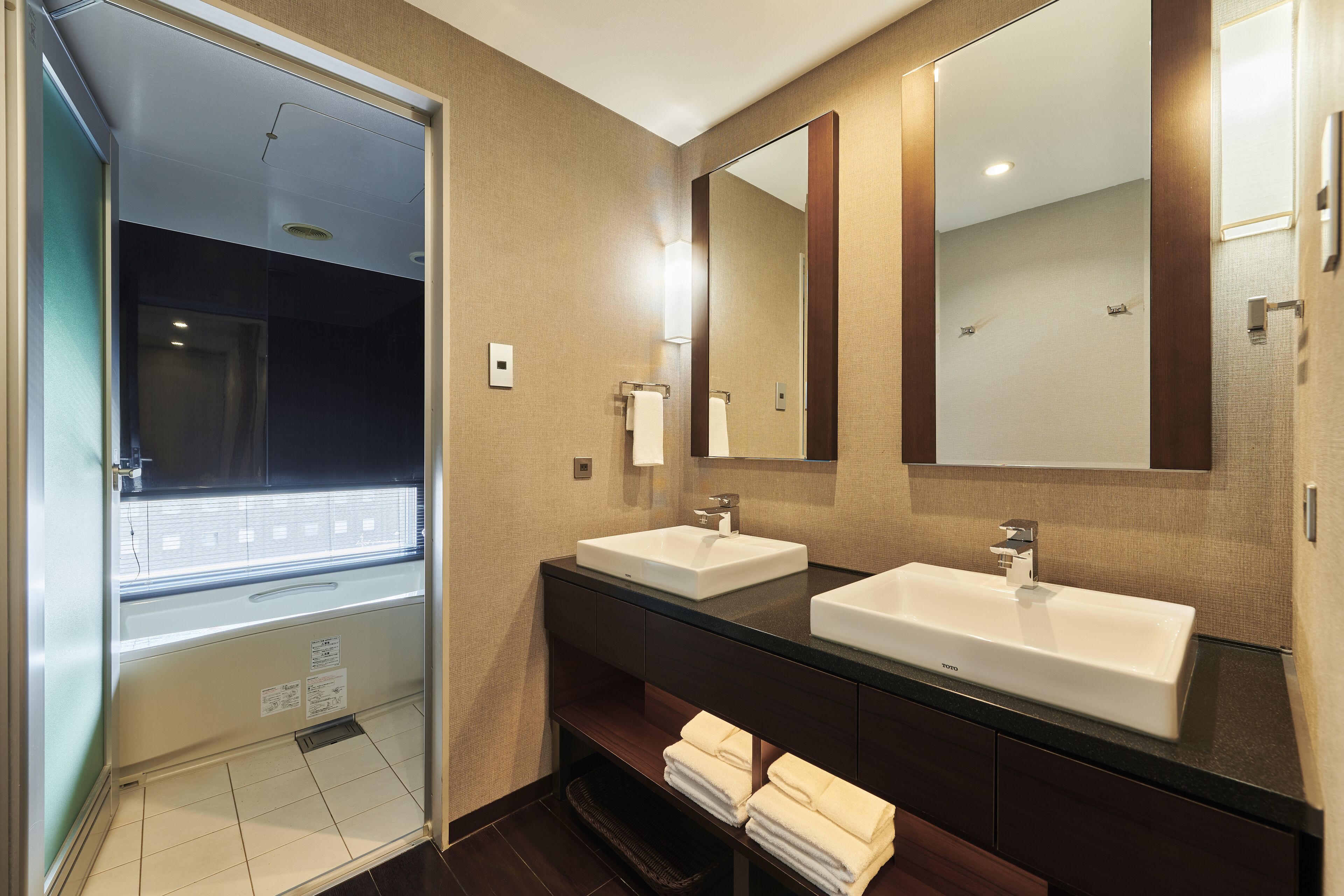 Een hotelbadkamer met twee wasbakken, een grote spiegel en een douche.