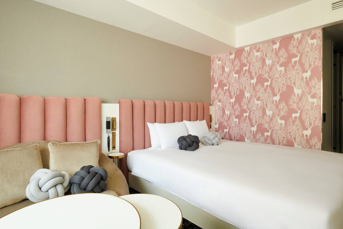 A hotel room with a bed, a sofa, and a small table.