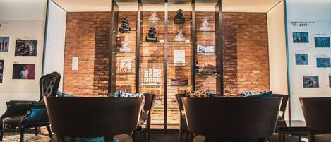 A reception area with a brick wall, glass display cases, and modern chairs.