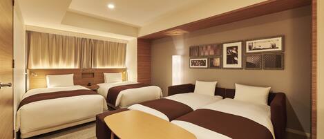 A hotel room with two beds, a wooden bench, and a wall with framed pictures.