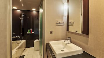 A modern bathroom with a white sink, a shower, and a toilet.