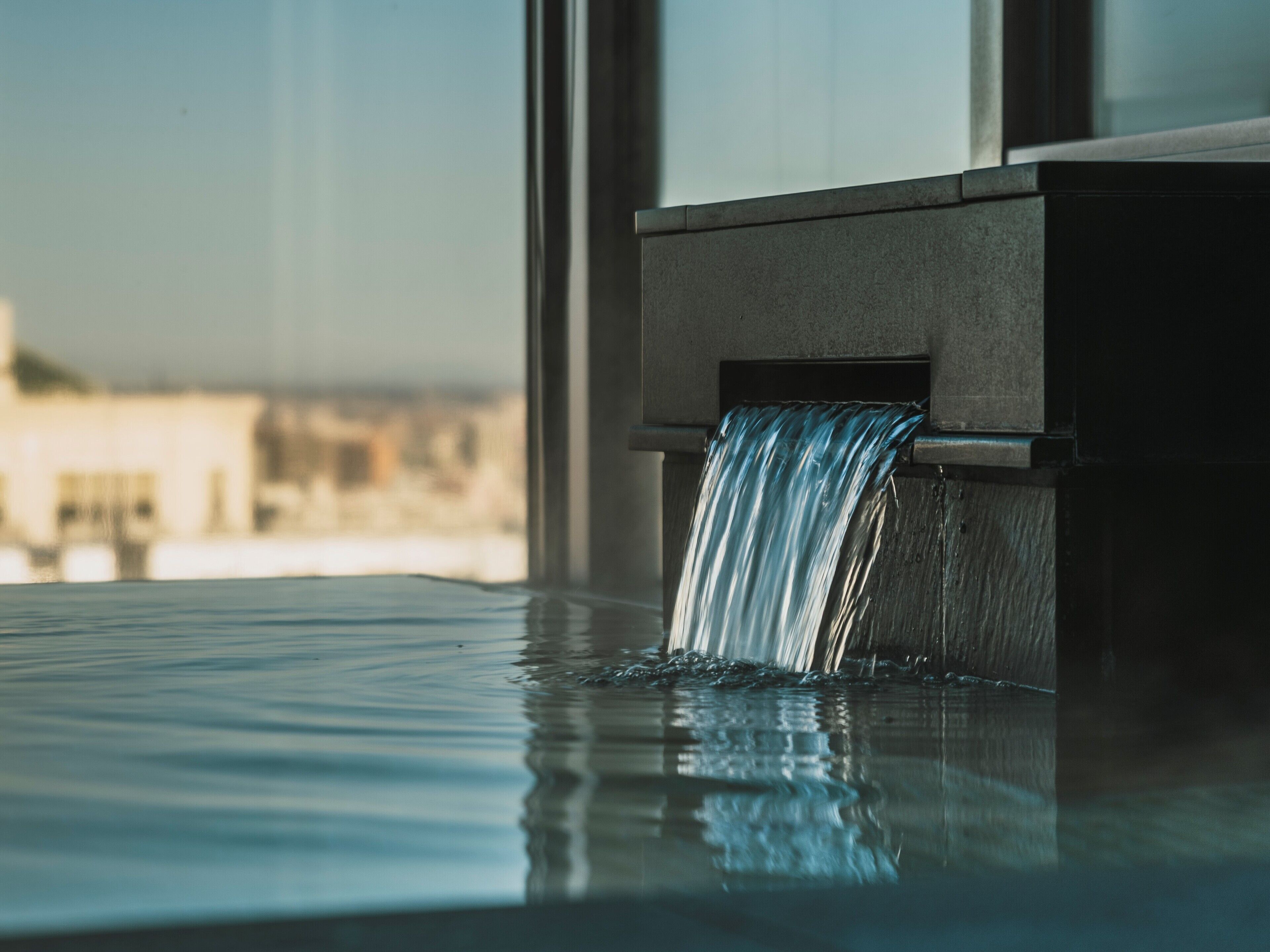 A water feature in a spa setting with a view of buildings in the background.