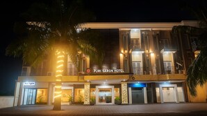Een hotel met een moderne gevel, een opvallende ingang en een bord waarop 'Puri Saron Hotel' staat.