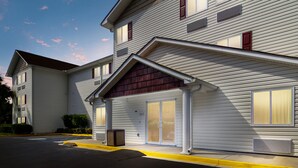 A two-story hotel with a flat roof, large windows, and a covered entrance.