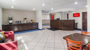 A hotel lobby with a reception desk, a microwave, and a coffee station.
