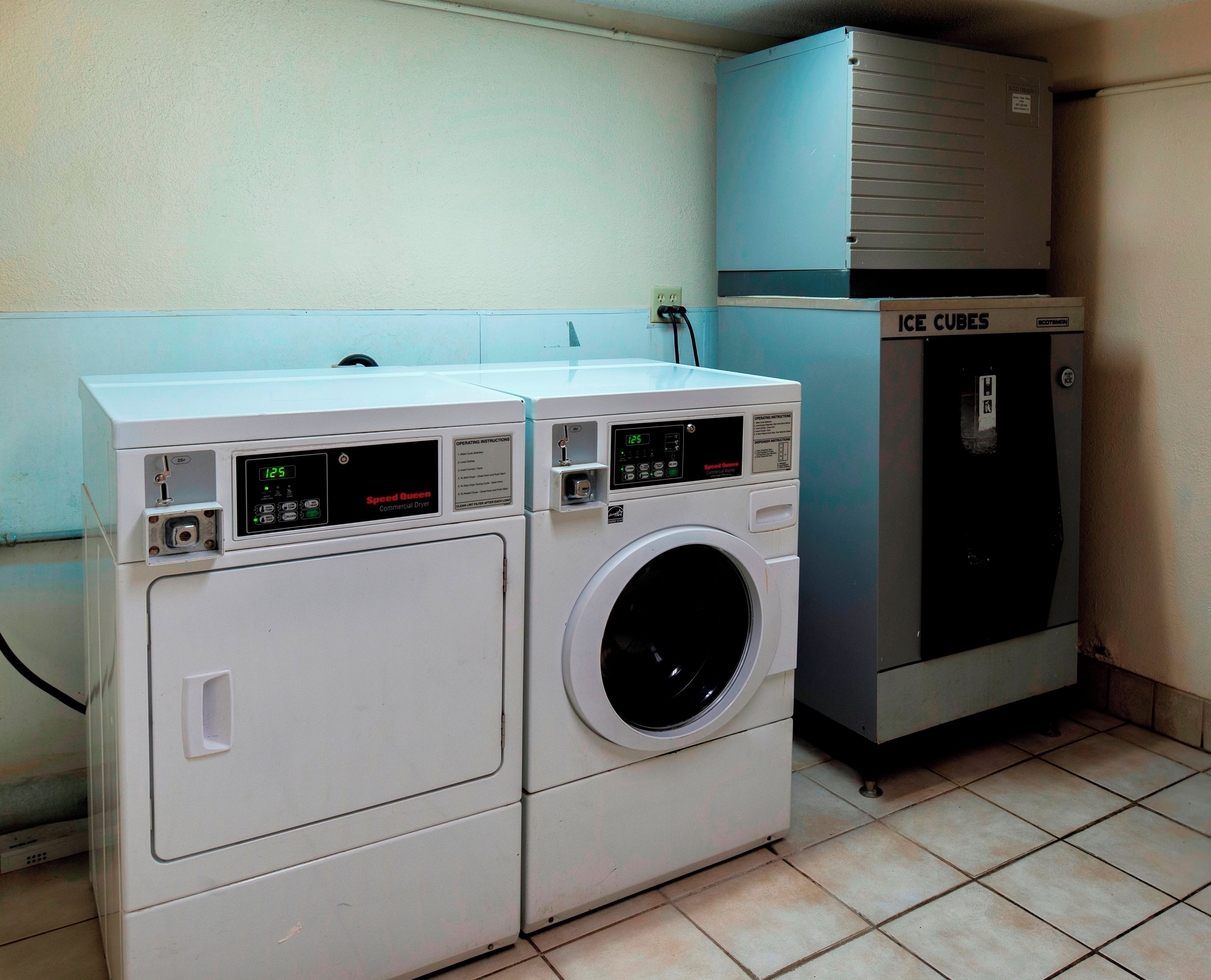 Een wasserette met twee wasmachines en een ijsmachine.