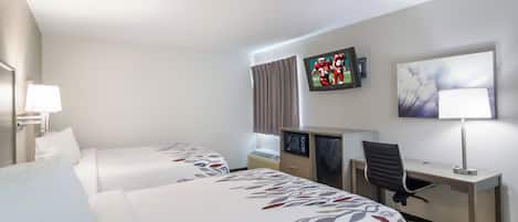 A hotel room with two beds, a desk, a chair, a television, and a painting on the wall.
