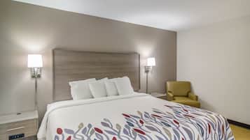 A hotel room with a bed, two bedside lamps, a chair, and a nightstand.